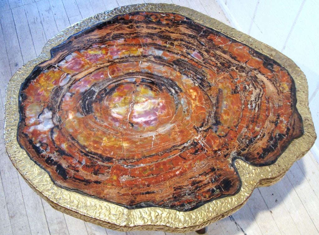 Stunning and unique, this rare cocktail table was created by French designer Henri Fernandez in 1980, and purchased in Paris at that time.  Table is comprised of a large thick slab of petrified wood with a hand wrought bronze base custom made to the