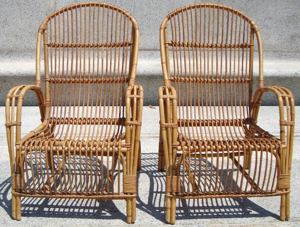 Sculptural pair of 1950's rattan lounge chairs, Denmark.  Interesting bucket shaped seat with continuous rattan rods that form the back, seat and front.  Beautiful craftmanship and quality- and comfortable too!
