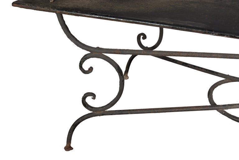 A Large Wrought Iron Garden Table with a tin/double layer metal top.