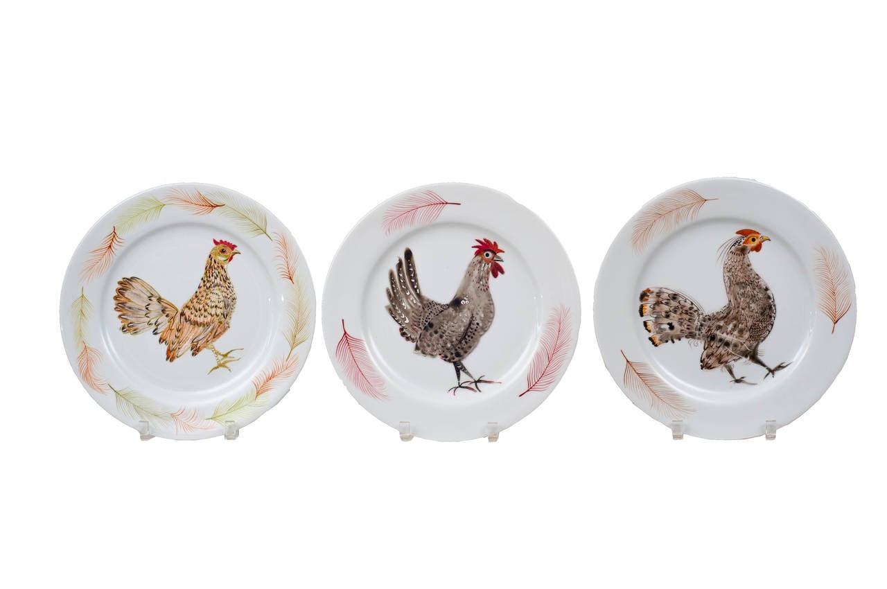 A set of nine hand-painted Limoges porcelain plates with rooster decoration.