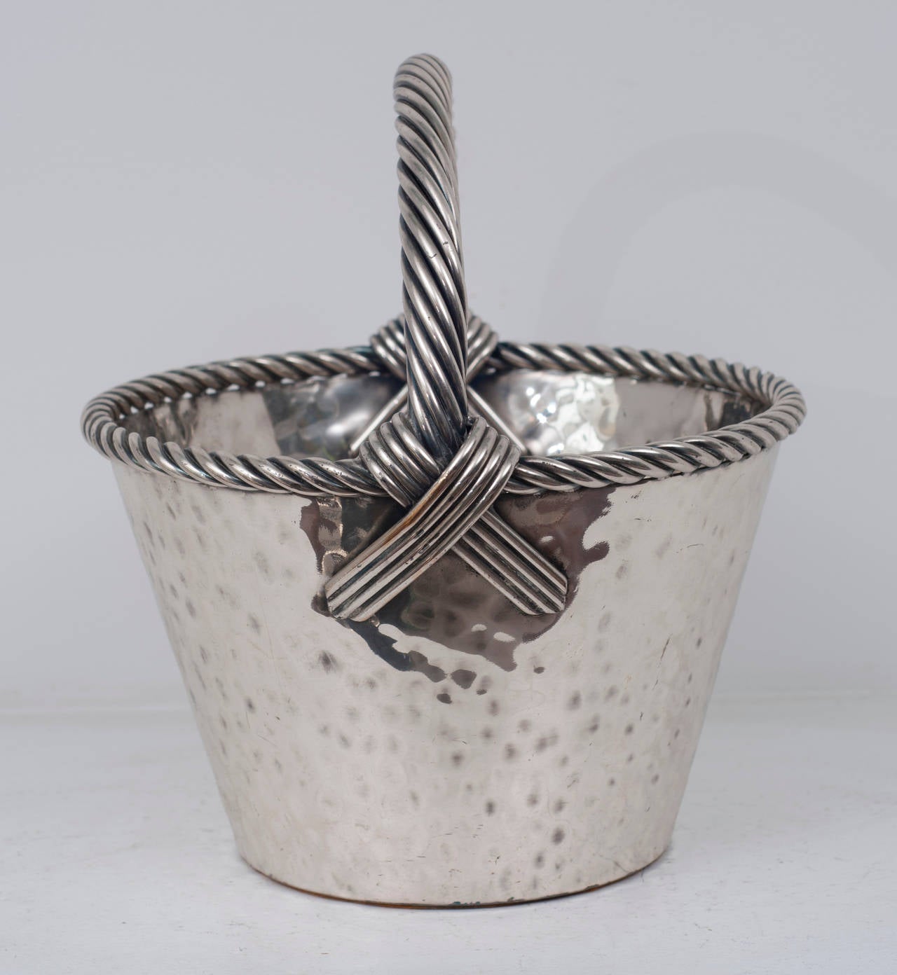 A silver plate basket with a rope handle.