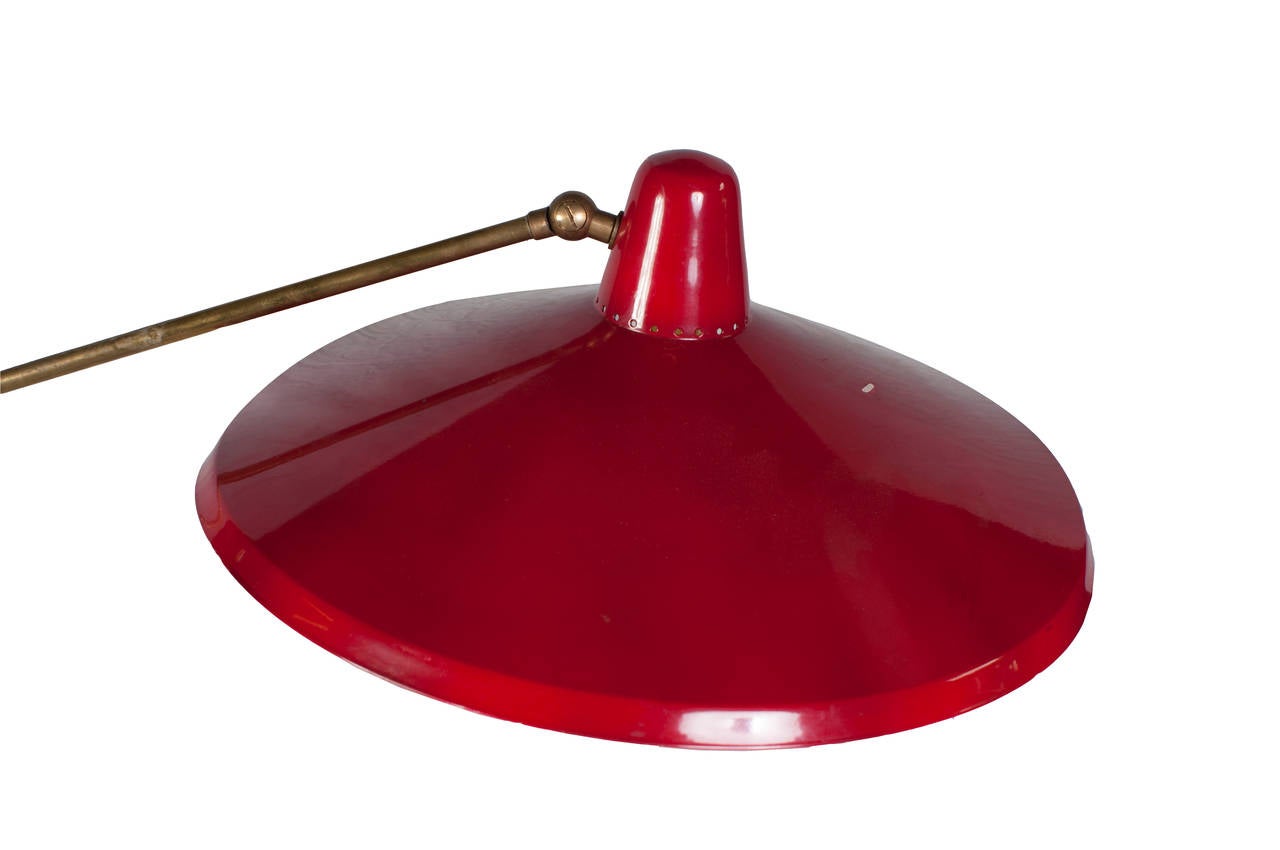 Un lampadaire italien à hauteur réglable avec un abat-jour en tôle rouge et une base en marbre.
Le diamètre de la base en marbre est de 12,25 pouces. 
La position la plus haute de cette lampe est de 57