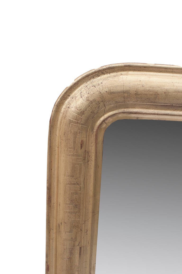 Gilt Louis Philippe mirror with rounded top and Greek key imprint.