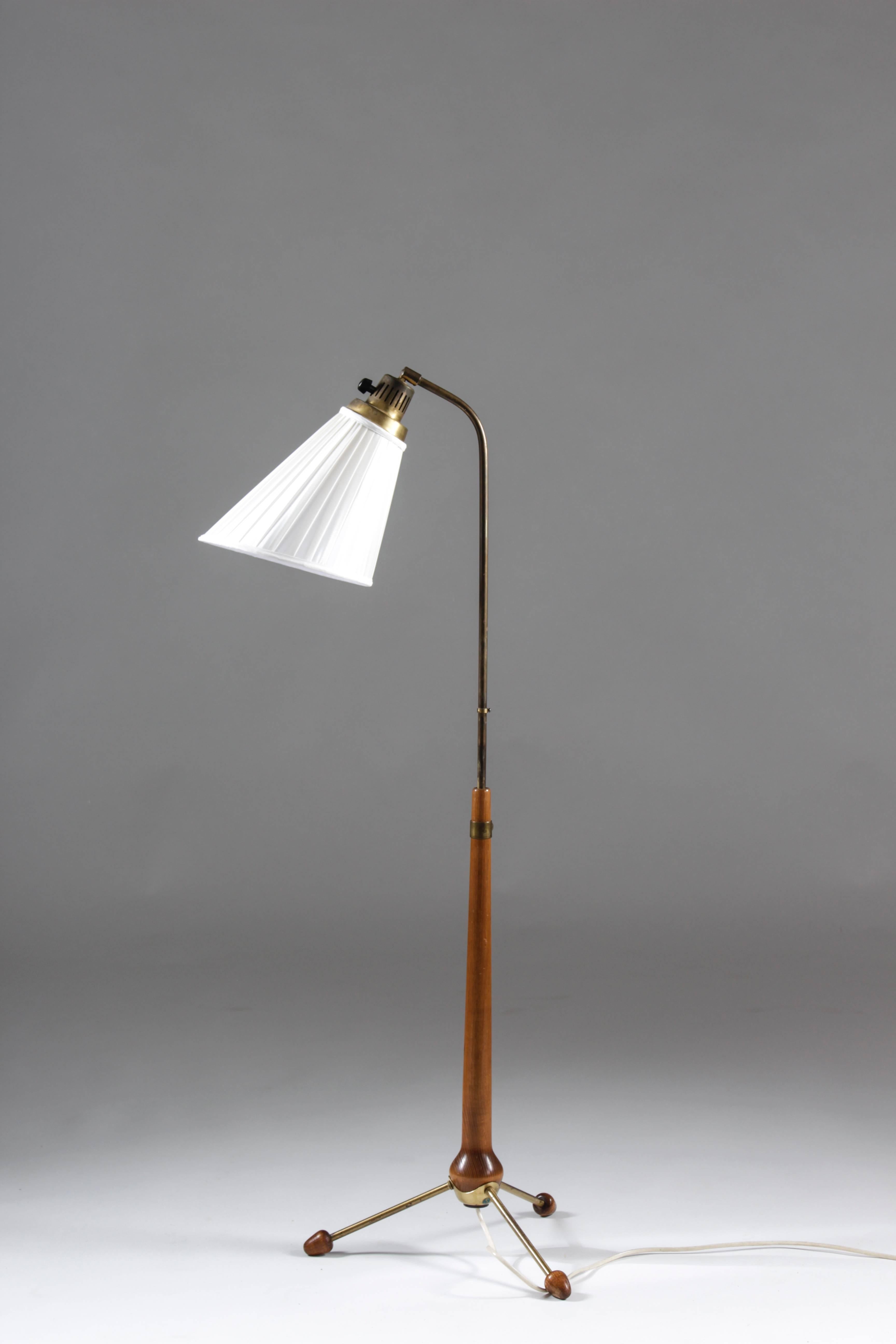 Lovely tripod floor lamp in brass and stained beech by Hans Bergström for Swedish manufacturer Ateljé Lyktan. The brass parts show a perfect patina and the wood is in excellent condition. The height of the lamp is adjustable. All parts are original