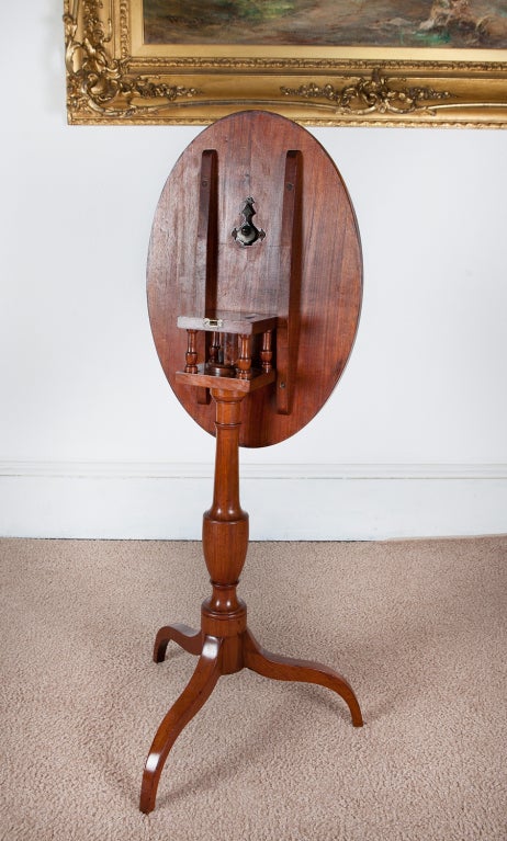 This delicate tilt-top candlestand features reverse cyma curve legs, an intact and beautiful birdcage revolving mechanism, and an excellently-turned urn pedestal. Probably made in Philadelphia