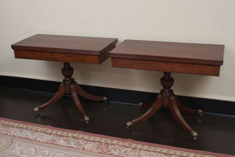 Mahogany and plum pudding mahogany with brass hardware. These game tables were truly made to be a pair, the grain in the flame mahogany top continues from one table to the other. Beautiful plum pudding mahogany on the skirt, excellent turned