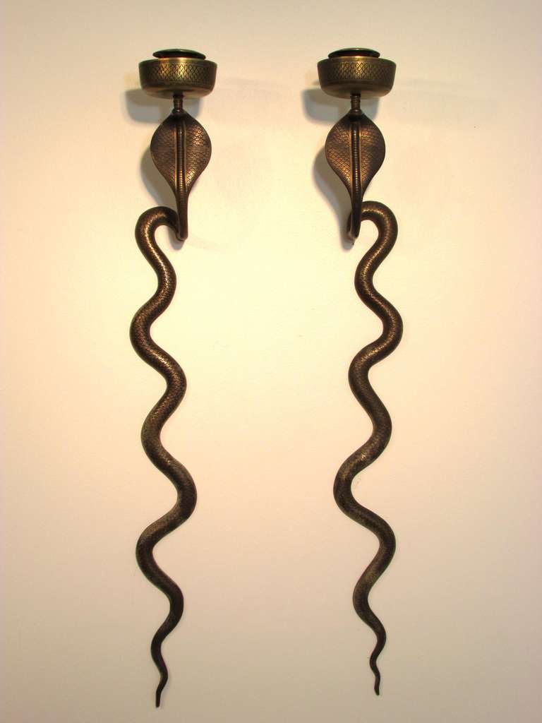 Pair of large hammered brass candle wall sconces depicting slithering cobra snakes.