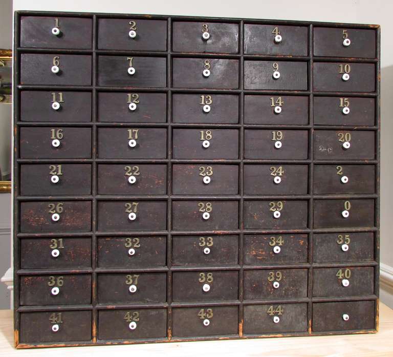 A 45 drawer numbered apothecary cabinet with white porcelain knobs interior of the drawers measure 2 3/8