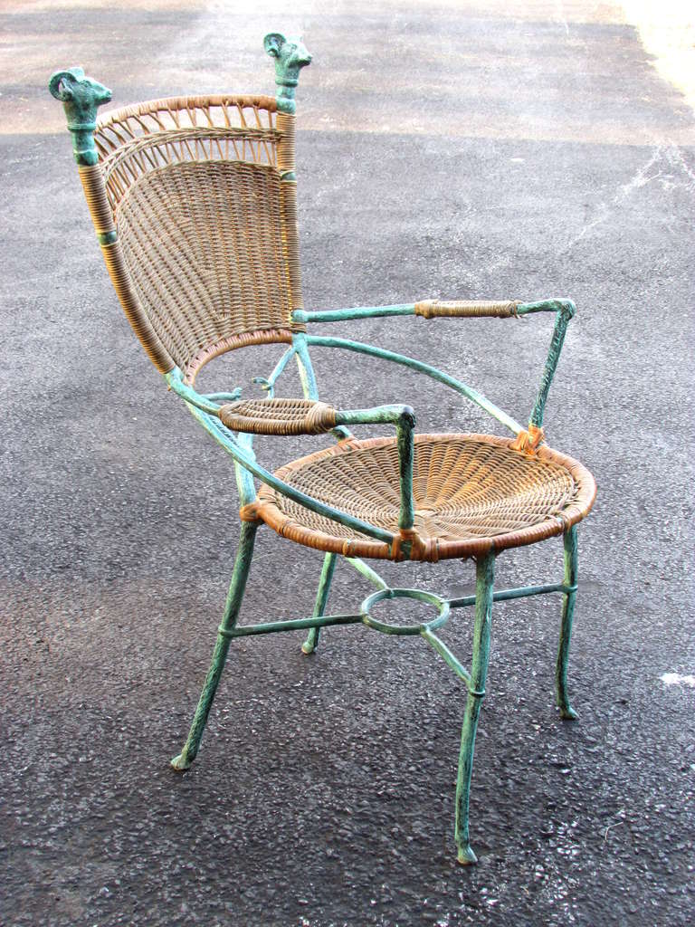 Patinated bronze and wrapped cane armchair with ram's head finials and hoot feet in the style of Diego Giacometti.