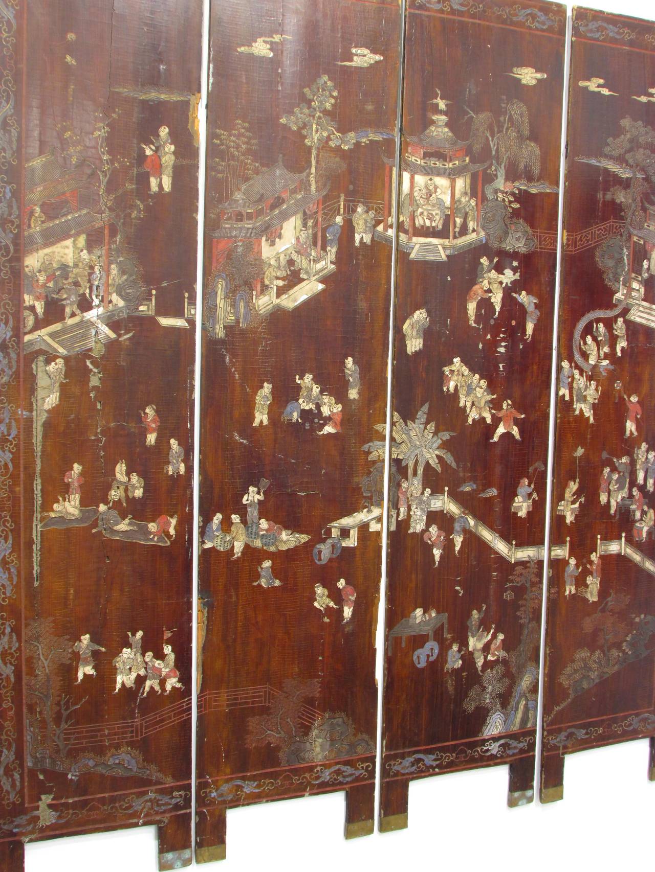 Four-panel brown lacquered coromandel folding screen depicting kids engaged in various games and activities screen is very worn and weathered and now disassembled and mounted as wall piece.