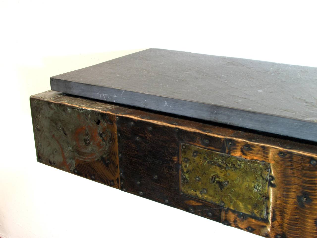 A wall mounted floating shelf with patchwork of copper bronze and pewter with slate top by Paul Evans