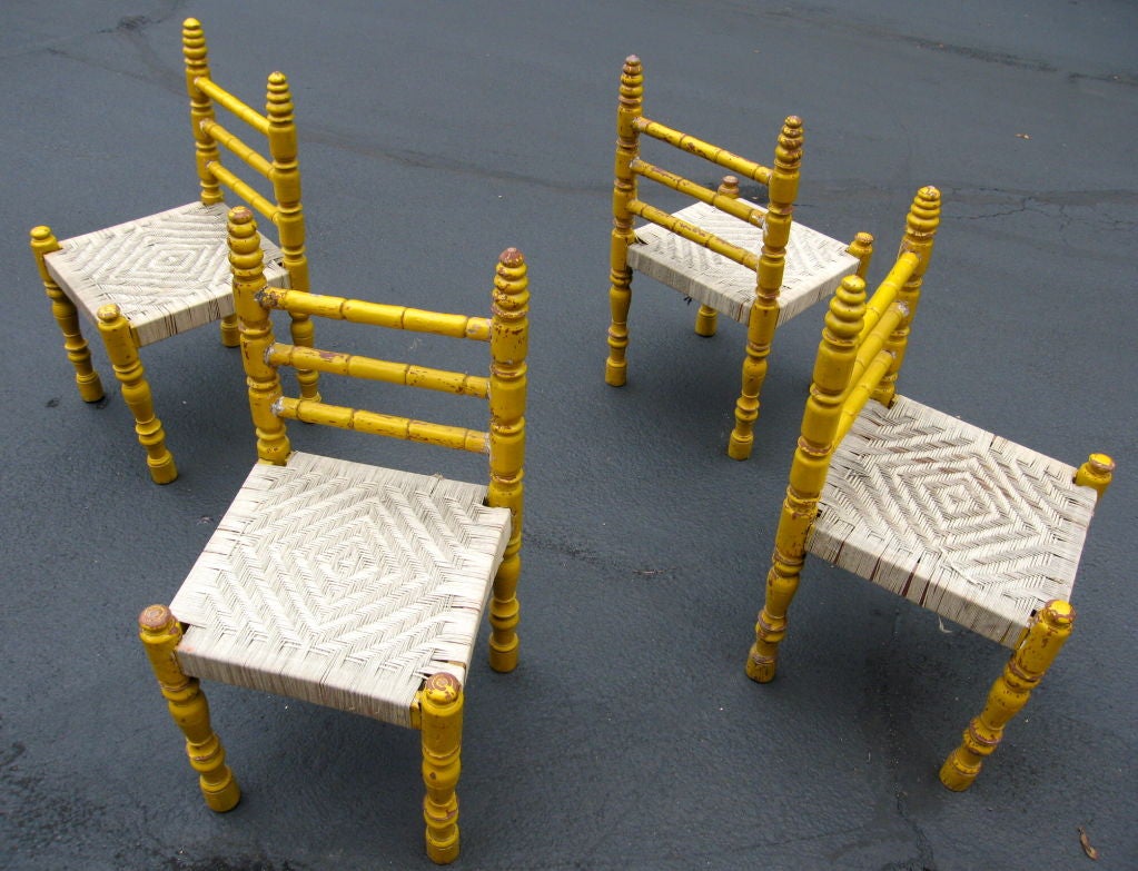 Set of four bright mustard yellow painted turned wooden chairs with woven string seats