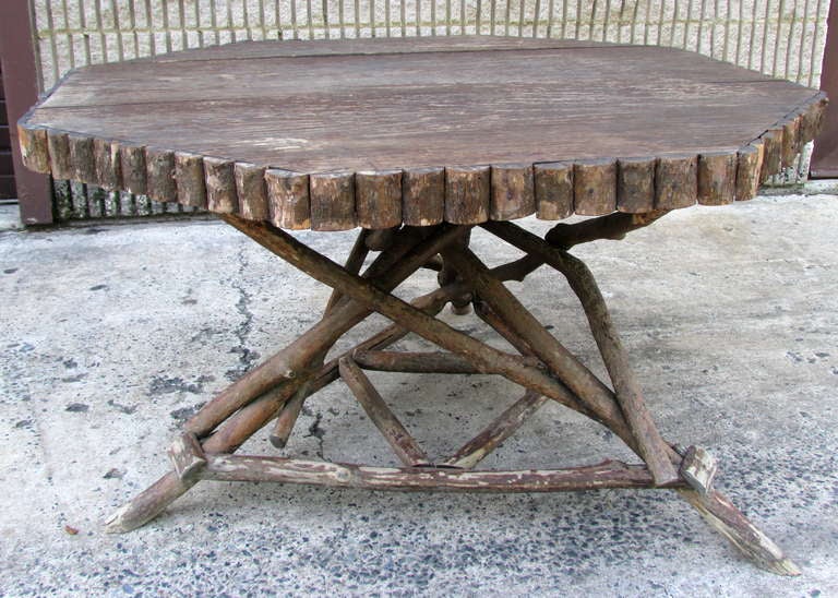 Worn and weathered octagonal shaped dining table with three twig legs and split sapling trim with a chestnut board top Provenance: Kate's Mountain Lodge Greenbrier, White Sulfur Springs WV