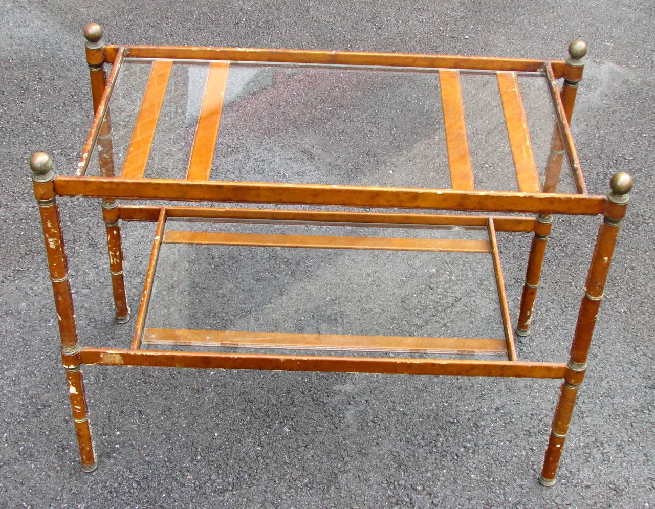 Two tiered end table with stitched leather covered metal frame and brass accents by Jacques Adnet
