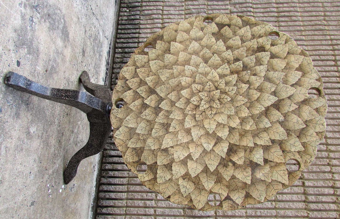 Tilt-top table with a intricate crushed eggshell design on top that depicts foliage measures 49.38 inches upright.