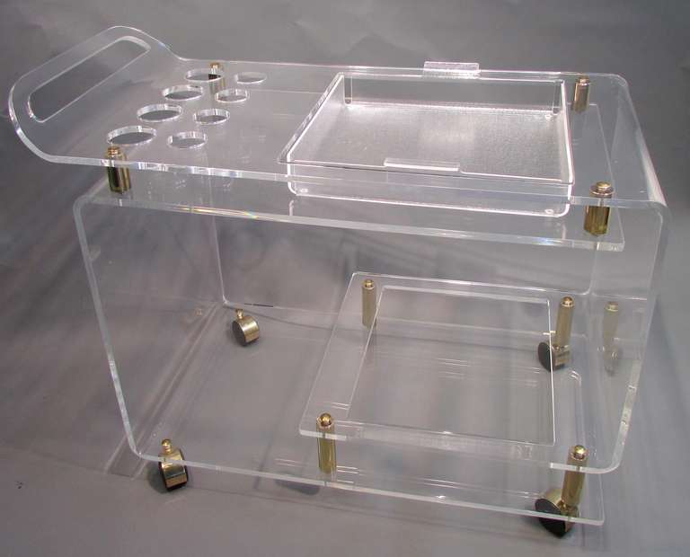 Beautiful rolling Lucite bar cart with compartments for glasses and bottles with inset removable serving tray