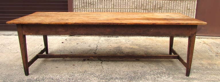 Very long French country farm table with brown painted base and natural wooden board top which has wonderful patina and wear