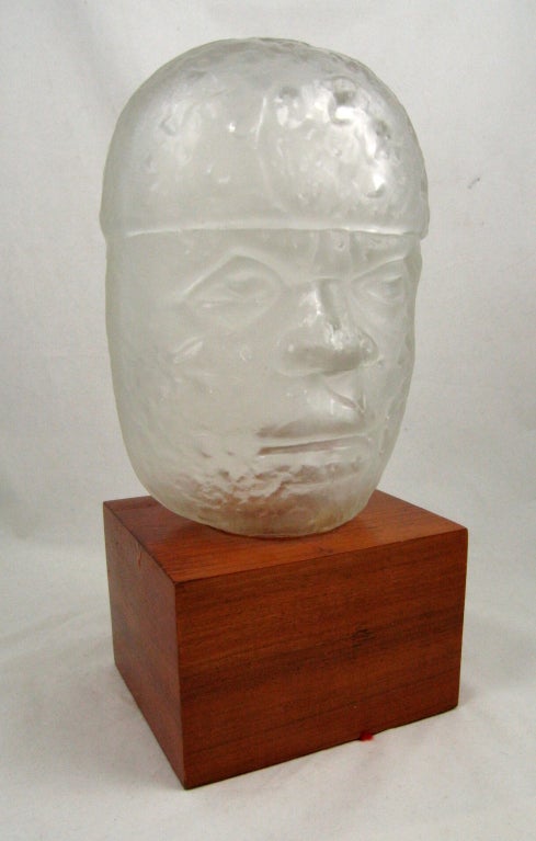 Glass head sculpture based on Olmec heads by Mexican architect Pedro Ramirez Vazquez mounted on wooden base signed in glass and on base