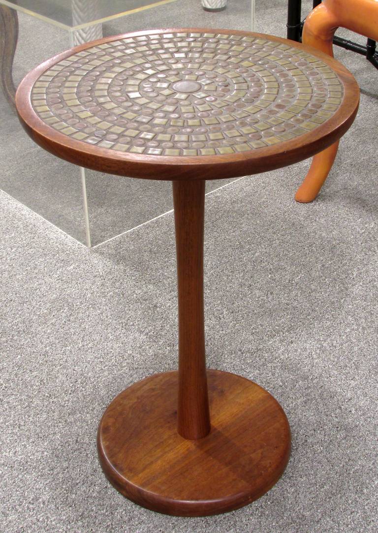 A walnut pedestal table with dark green glazed tiles inset by Gordon Martz