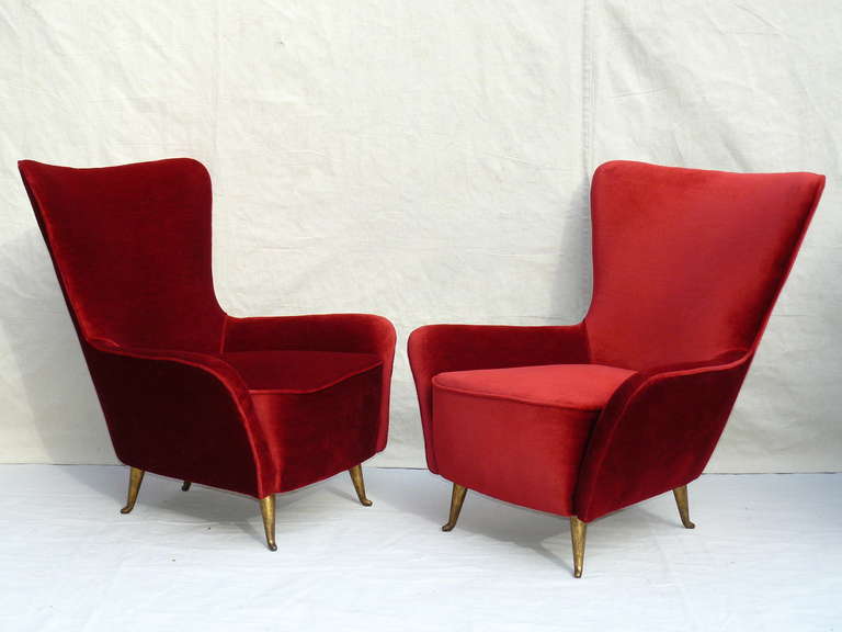 Two Pairs of 50's Italian lounge chairs by ISA with gilt metal legs, upholstered in a ruby red velvet. Petite in size and scale. Very heavy and well made. Very high quality. ISA foil labels visible underneath the bottom scrim. Price is PER PAIR.