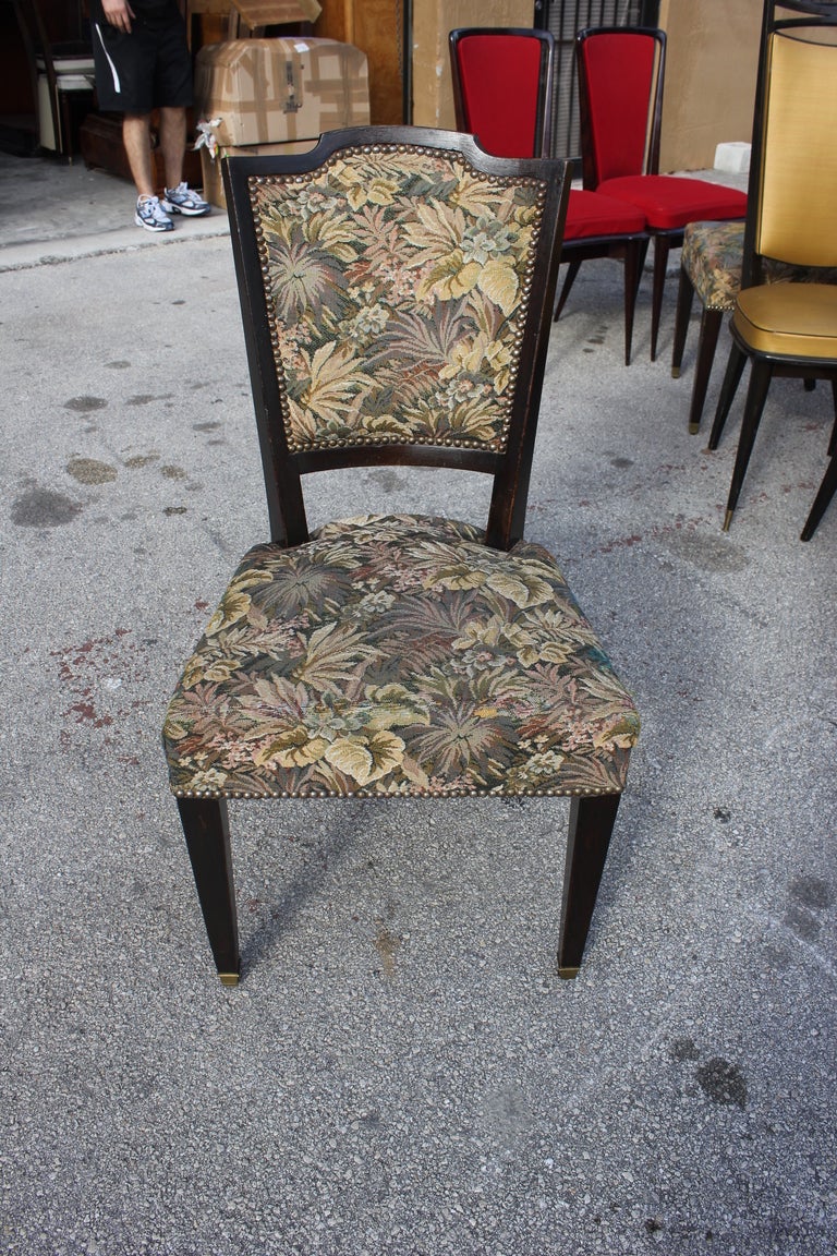 Set of 8 French Art Deco ebonized walnut dining chairs with Aubusson-type upholstery.