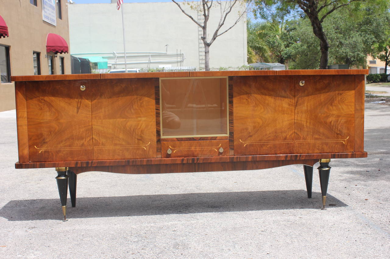 A French Art Deco or art moderne exotic walnut buffet or sideboard, circa 1940s. Finished interior, all keys present. Center display area.