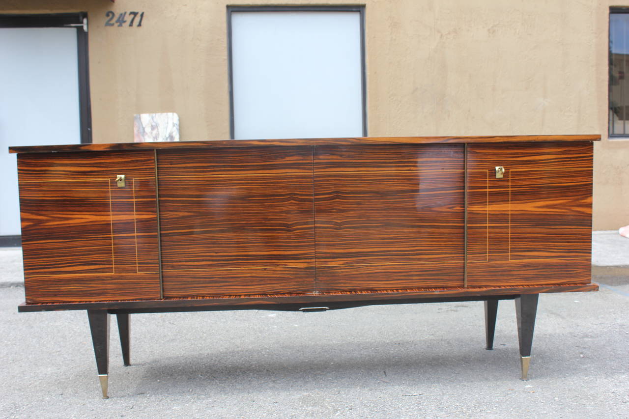 A French Art Deco exotic Macassar ebony buffet, circa 1940s. Interior fitted with shelves and finished in lemonwood.
