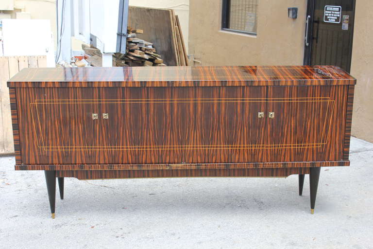 A stunning French Art Deco or art moderne exotic Macassar ebony buffet or sideboard. Interior finished in lemonwood. Interior drawer and shelf space. Original keys present.