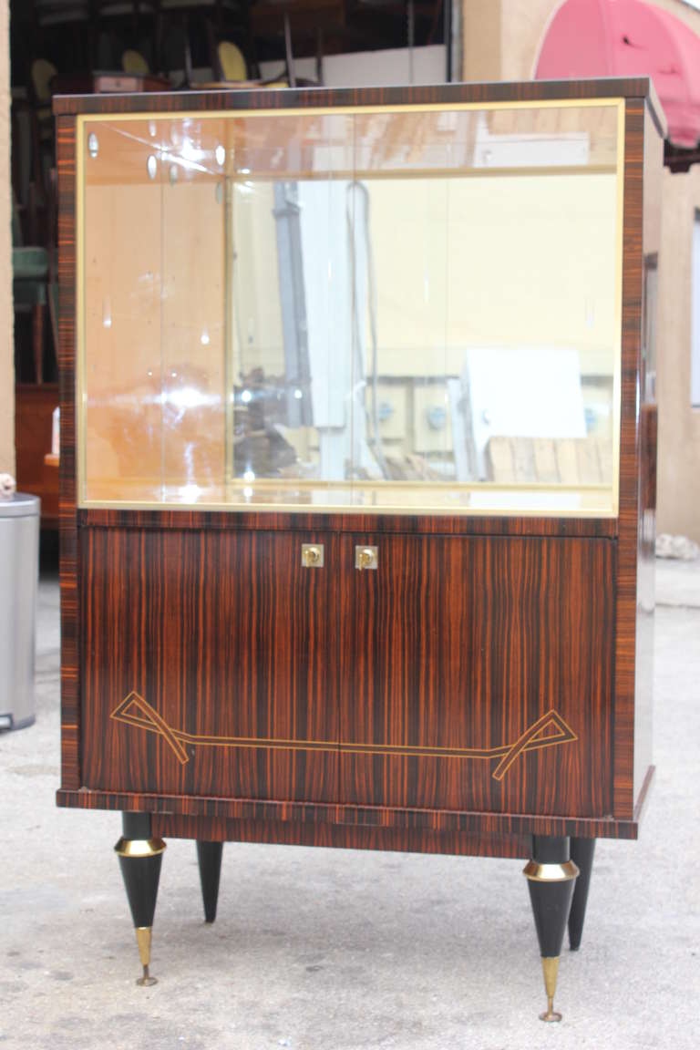 A French Art Deco/ Art Moderne Exotic Macassar Ebony Dry Bar/ Display Cabinet, circa 1940's. Interior finished in Lemonwood. Key present.