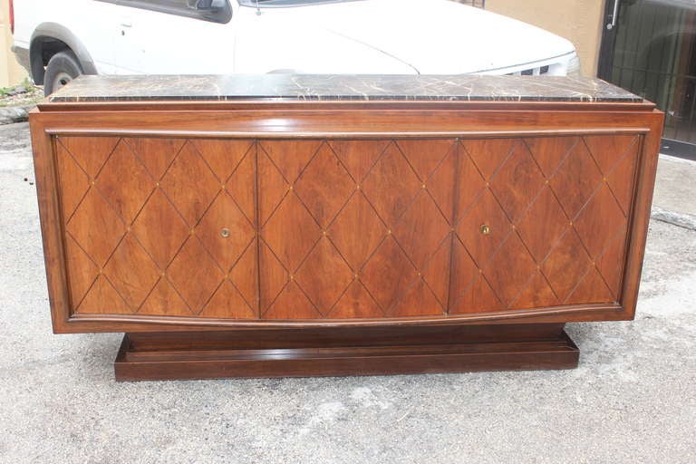 A French Art Deco palisander buffet by famed designer Challeyssin. Bronze diamond detail. Marble top. Interior finished.