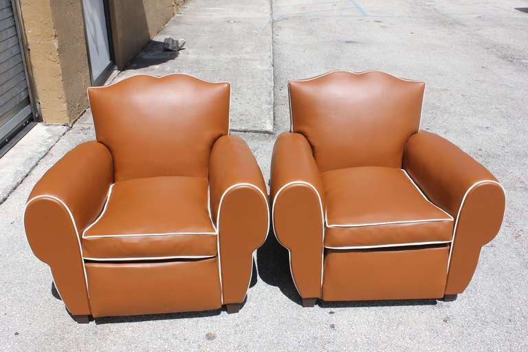 Pair of very comfortable French Art Deco moustache back club chairs, newly reupholstered in vinyl. Fully restored. Feet have been replaced.