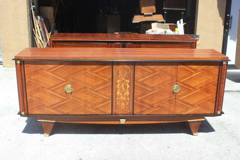 A French Art Deco palisander buffet with mother-of-pearl center detail in the style of Jules Leleu. Bronze hardware. Elaborate center panel.