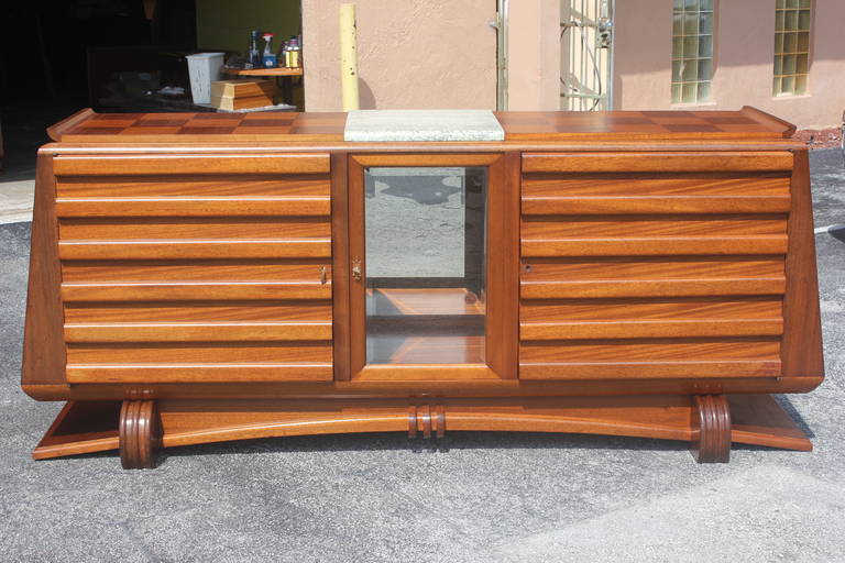 A French Art Deco masterpiece buffet in solid mahogany by Gaston Poisson, circa 1940s. Centre marble top, exquisitely carved, pyramid form. Finished interior.