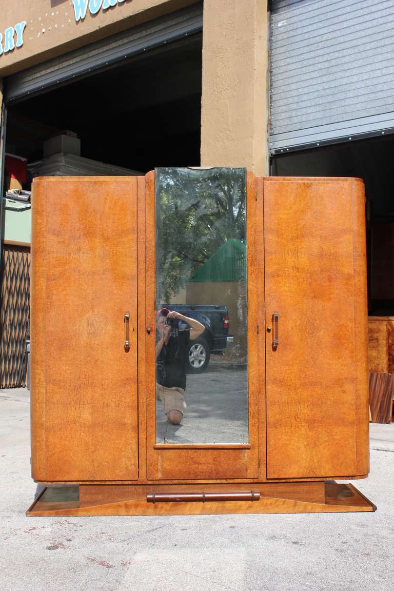A French Art Deco burl Amboyna armoire or wardrobe. Three-door, center mirror.