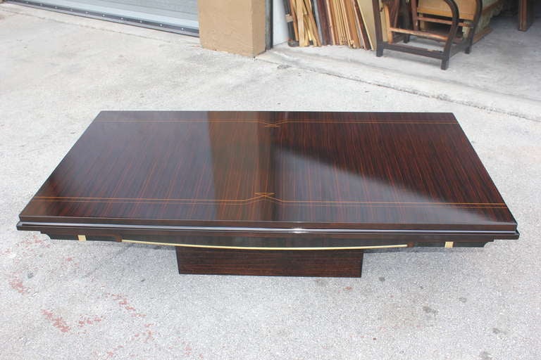 A French Art Deco exotic Macassar ebony coffee or cocktail table on Macassar base. Brass accents.