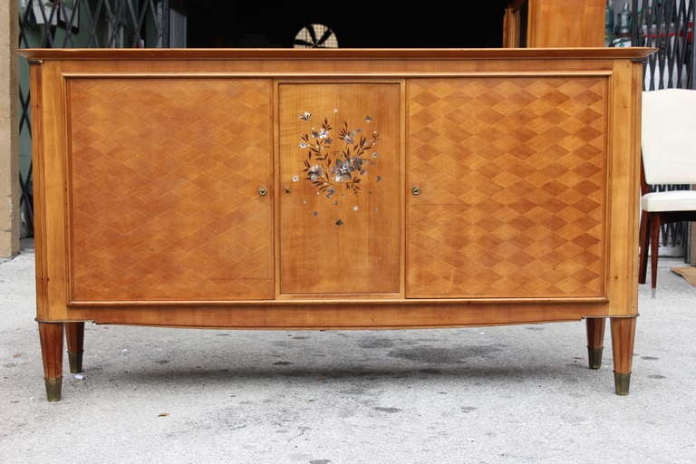 A French Art Deco masterpiece buffet in sycamore with mother-of-pearl by the Design Firm Dominique. Founded by Marcel Genevriere and André Domin, this piece dates to the 1940s. Spectacular all the way around, with bronze accents and stunning inlay.