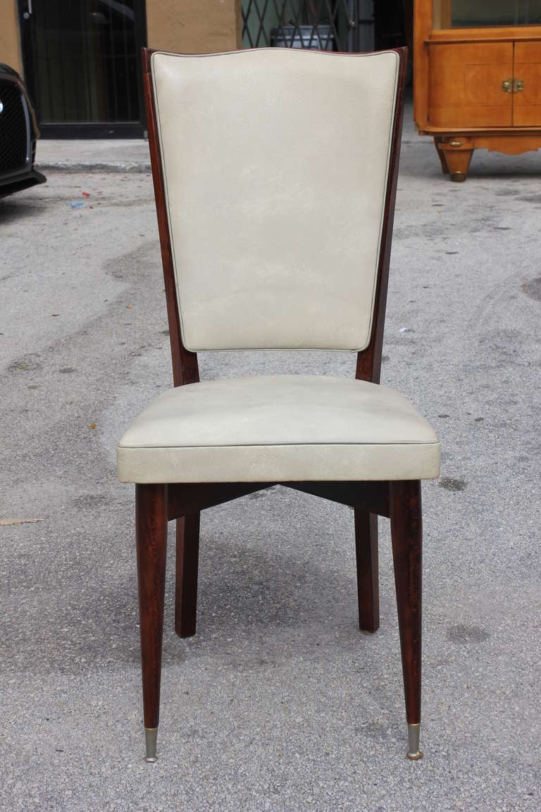 A set of eight French Art Deco walnut dining chairs, circa 1940s.