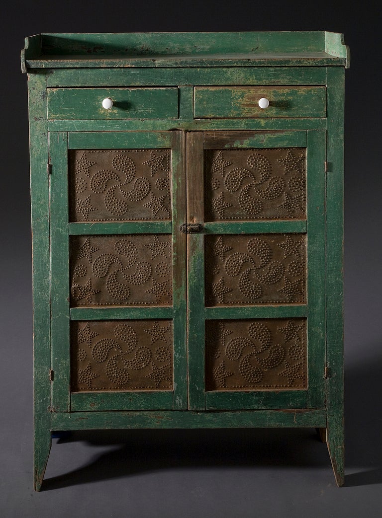Pie Safe
19th Century
Pennsylvannia
Pine with original green paint. Punched tin Doors with two interior shelves. Gallery on top. Porcelain knobs in two drawers.