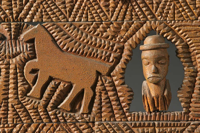 Late 19th century - early 20th century
Unidentified artist. Southern United States.
Chip carved crate wood and brown paint. 
Noah and his family peer out of the ark as small
horses and other animals enter. This African American 
carving was