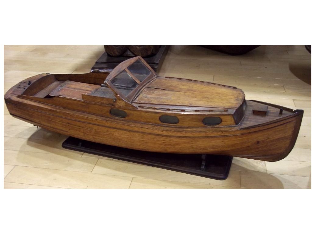 A vintage wooden model of a boat with removable panels to view cabin and lower deck. Boat may have been electrified at one time with running lights and working motor. Comes with stand.