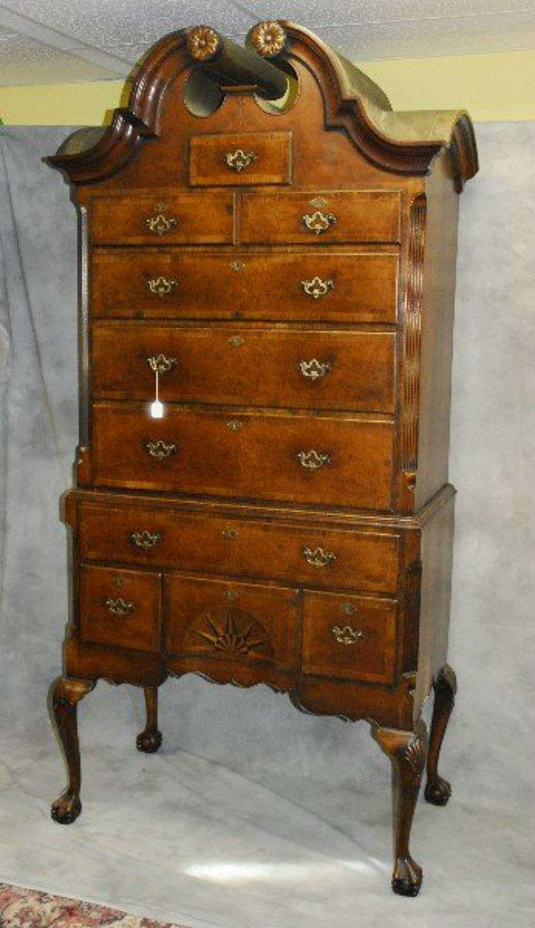 Chippendale walnut bonnet top two-part highboy, having a scroll molded double bonnet top over six drawers, the four drawer base with one long drawer and three short drawers; the center drawer having an elaborate inlaid star pattern, shaped apron on