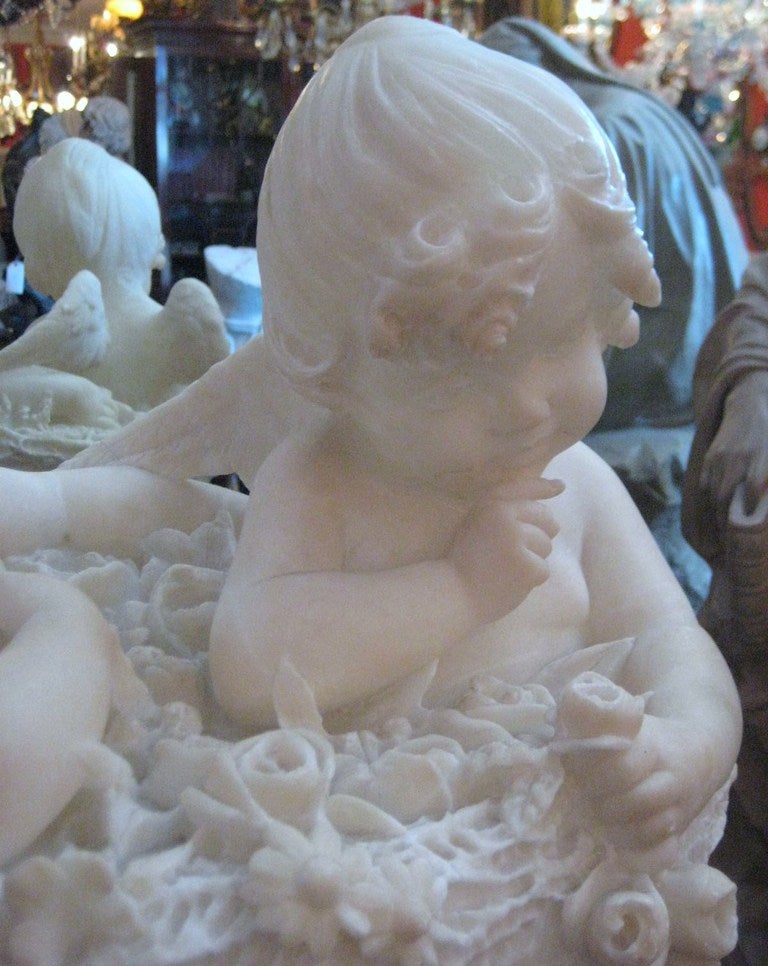 Continental carved marble group of two Angels seated in a basket of flowers In Good Condition In Miami, FL
