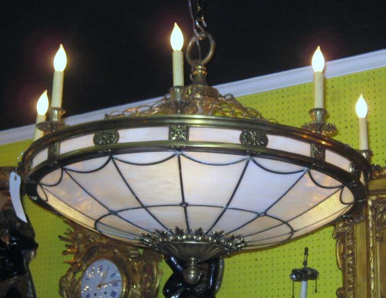 Victorian style bronze and slag glass twelve-light chandelier, having four interior lights and eight outer rim lights.