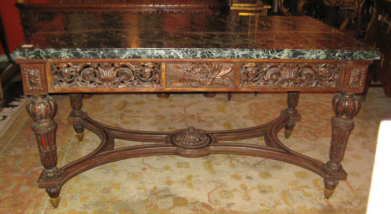 Louis XIV carved walnut center table, having a rectangular antico verde marble top above a pierce carved frieze on beautifully carved legs joining a shaped stretcher support on bronze mounted toupie feet.