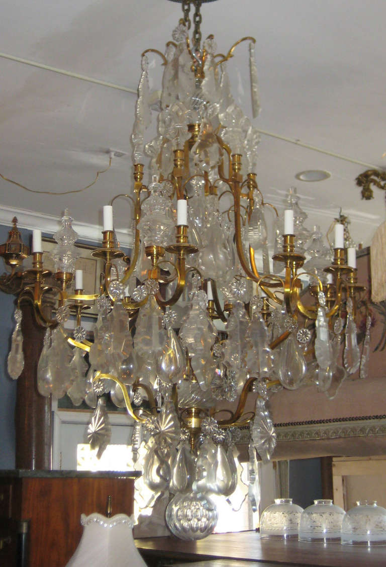 Large 19th c. Louis XV style bronze and crystal twelve-light chandelier, with spires, fleur-de-lys, French pendeloque, pear, rosette and other pendeloque crystals and terminating with a large faceted spherical ball.