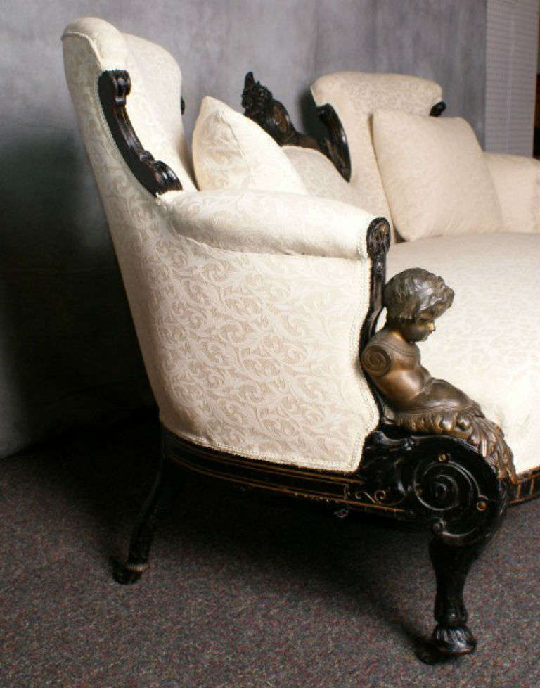 American Victorian bronze-mounted ebonized sofa, possibly Jacque Alexander Roux (French/American 1813-1898), having shaped arms with bronze mounted figures, the top rail centering a bronze medallion.