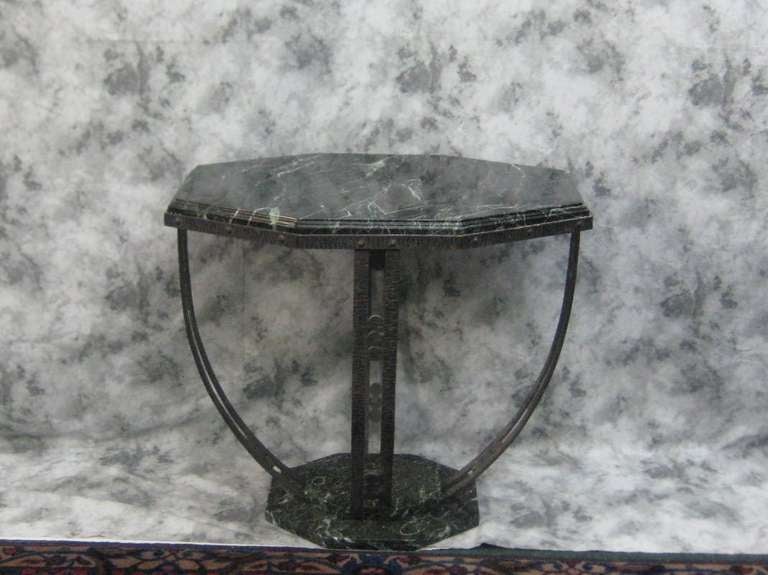 Pair of Art Deco iron and Verde marble side tables possibly Segar Studios, unsigned, having an elongated inset hexagonal top with molded edge, hammered iron frame on a Verde marble hexagonal base.