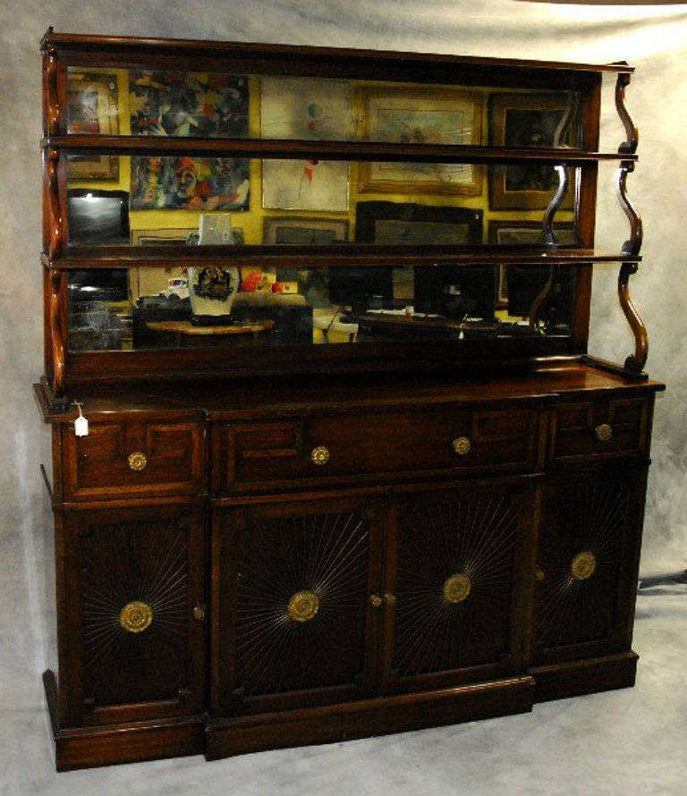 Regency mahogany two-part hutch-top chiffonier/buffet; the hutch top with two long shelves and mirror back above the base centering a long drawer flanked by two short drawers over four cabinet doors with brass starburst pattern grille fronts and