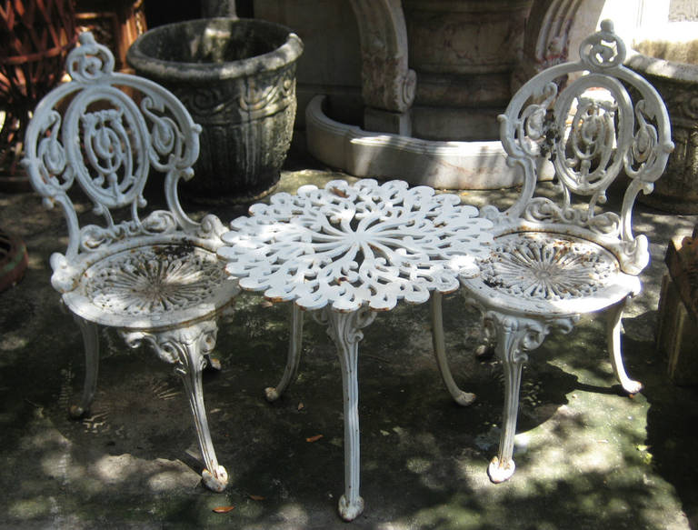 Victorian wrought iron white painted three-piece garden set. Measures: Chair height 31.5, width 15