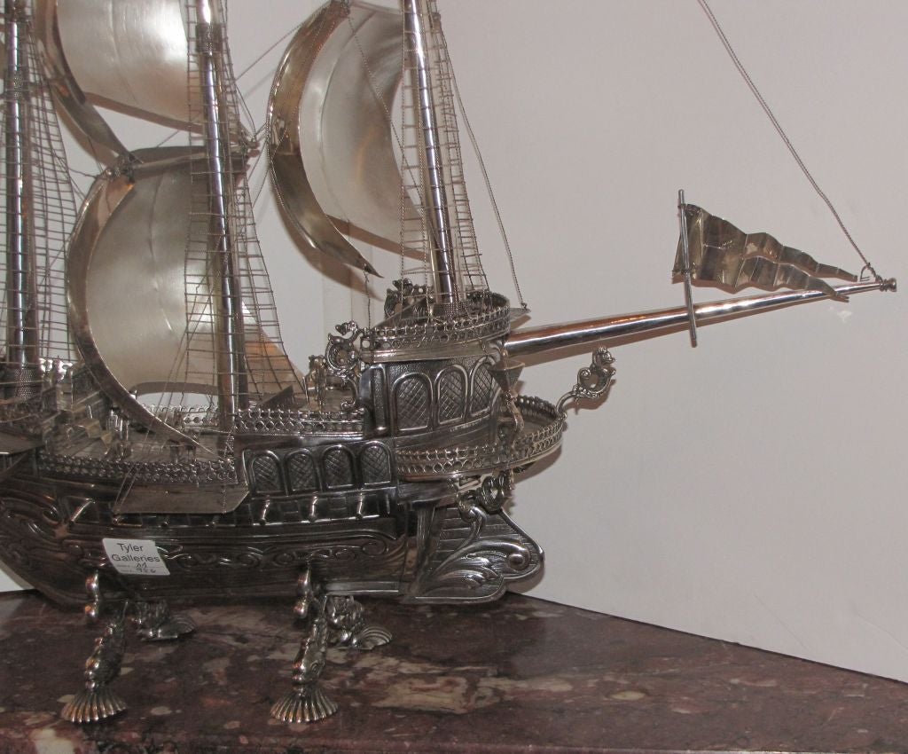 Large Silver Ship Model (Nef), in the form of a triple masted sailing ship, fully rigged and flagged and fitted with cannons and figures on dolphin legs ending with shell feet; hallmarked with .915 Spanish Silver marks.